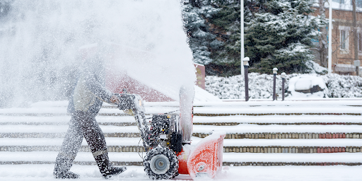 worker using snow blower
